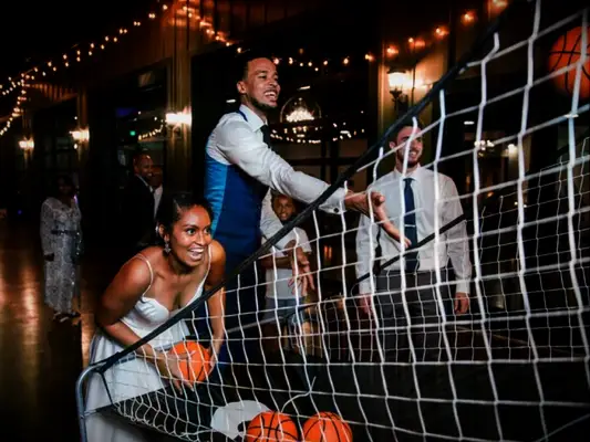 Couple playing basketball at wedding reception