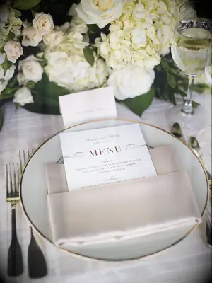 This chic wedding place setting features timeless colors in white, beige and gold.