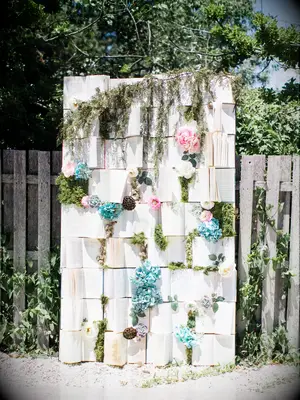 wedding backdrop made with open vintage books, pink and blue flowers with greenery