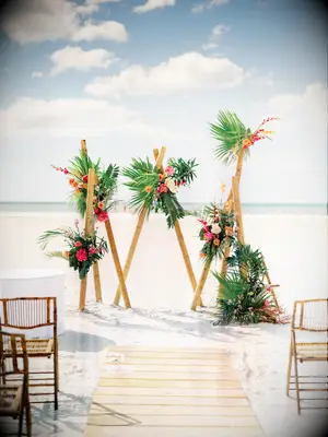 beach wedding arch alternative with bamboo poles and tropical flowers