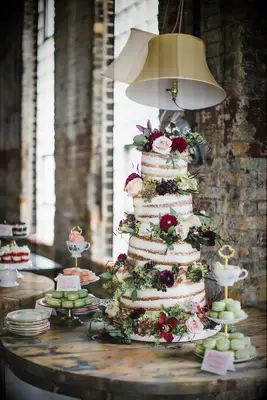 unique four tier wedding cake with tilted tiers and flowers in between each tier