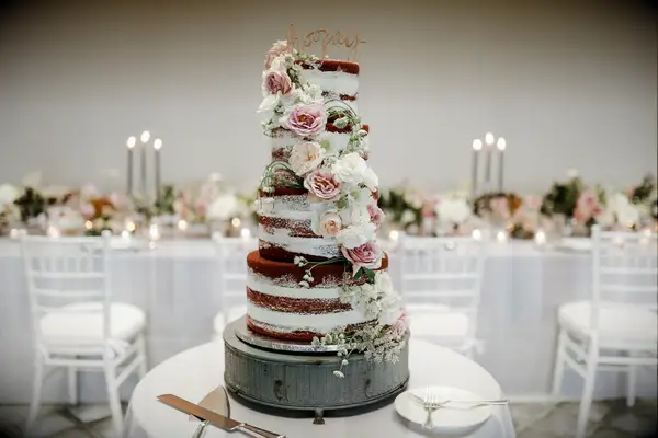 four tier semi naked wedding cake with chocolate sponge, pink and ivory roses and queen anne