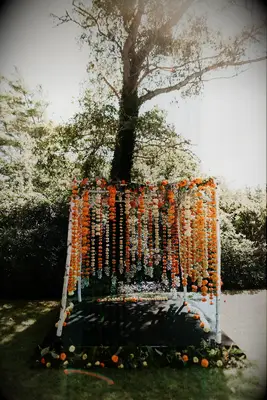 Rustic mandap with orange flower garlands