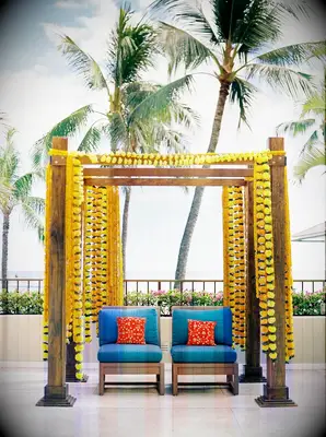 Mandap with yellow flowers and blue chairs