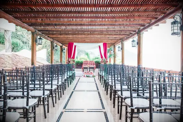 Fabric mandap and black Chiavari chairs on open-air terrace
