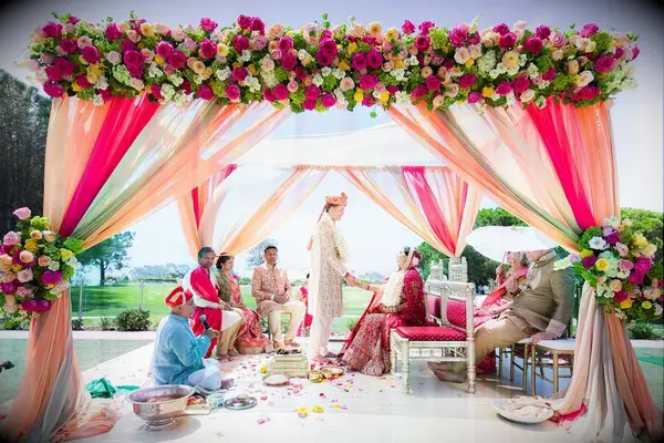 Bright pink mandap with draping and floral accents