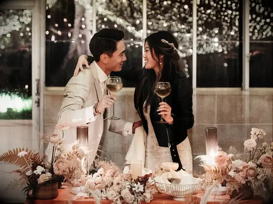 Groom with bride wearing leather jacket toasting during wedding reception