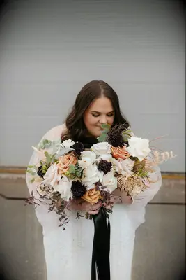 Bride holding bouquet with scabiosa and roses