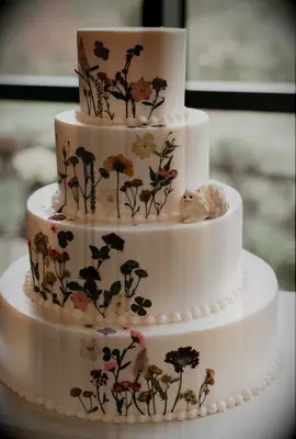 Tiered white wedding cake with wildflower designs