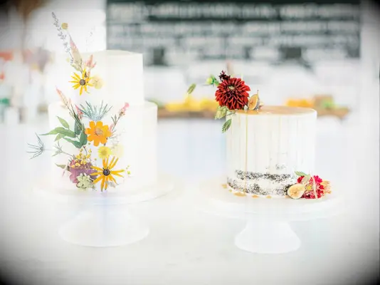 Two rustic wedding cakes with pressed flowers