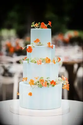 four-tier sky blue cake with orange nasturtiums