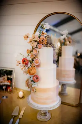Three-tier orange ombre wedding cake with orange flowers