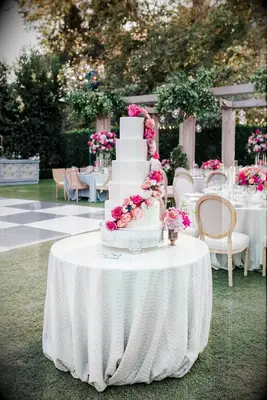 White tiered wedding cake with pink roses