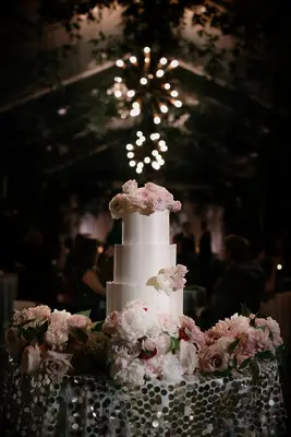 Tiered white wedding cake with white flowers