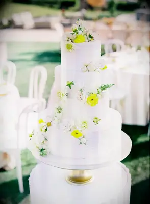 White wedding cake with yellow and white flowers