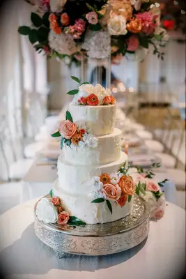 White buttercream wedding cake with fresh flowers