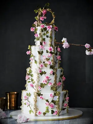 Ornate four-tier wedding cake with pink flowers