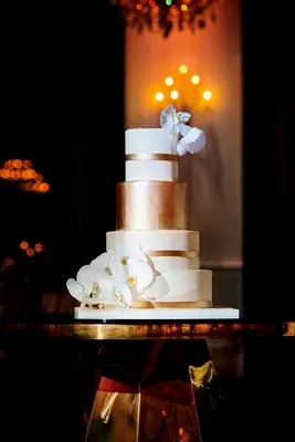 Gold-and-white wedding cake with orchids