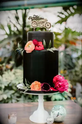 Two-tier black wedding cake with motorcycle cake topper