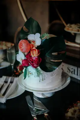 One-tier wedding cake with monstera leaf decorations