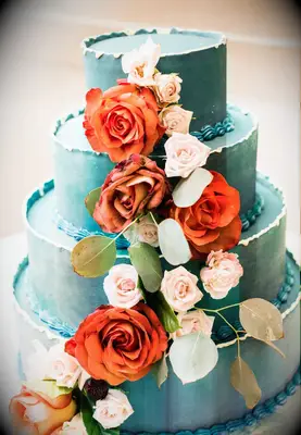 Four-tier teal cake with fresh red roses