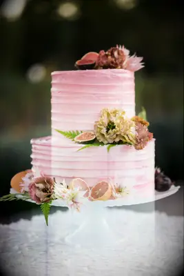 Two-tier pink cake with fresh fruit decorations