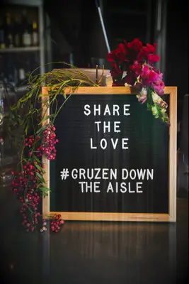 wedding pegboard hashtag sign decorated with pink flowers and letters that say share the love