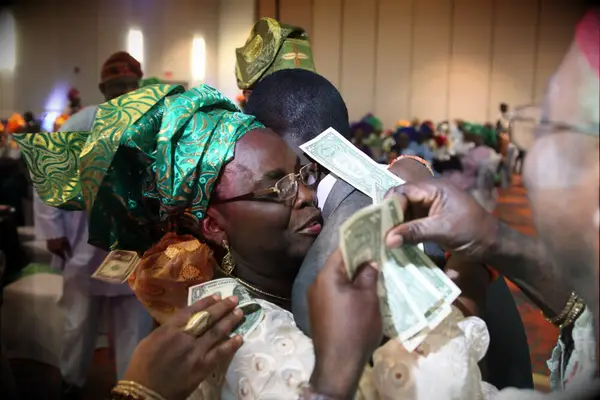 Couple engages in a traditional Nigerian money dance. 