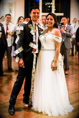 Couple smiles at the camera after their traditional money dance. 