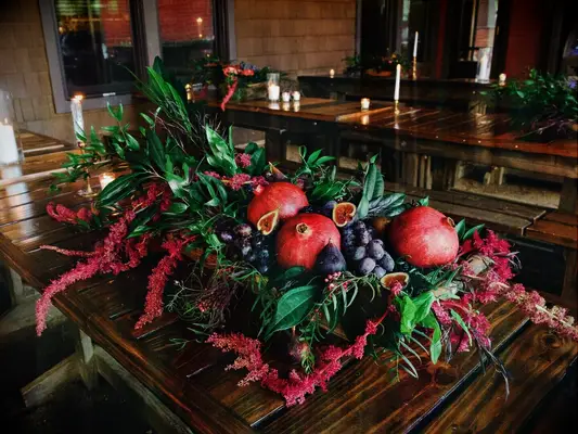 Pomegranate red fig black grapes greenery flower wedding table arrangement