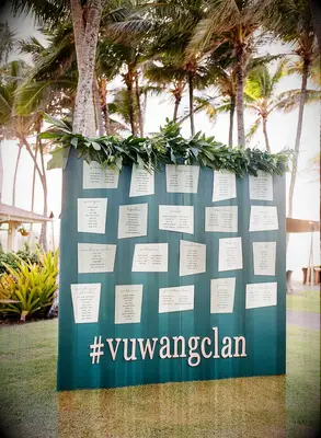 Tropical seating chart board at beach wedding