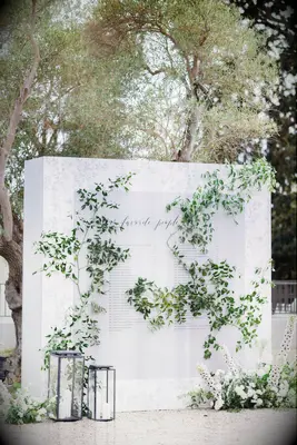 Large white seating chart display with greenery decorations