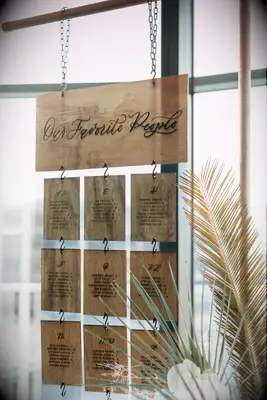 Laser-cut wood seating chart hanging from copper frame