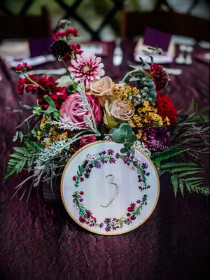 Dark purple, yellow, pink, and green hand-sewn table number, 
