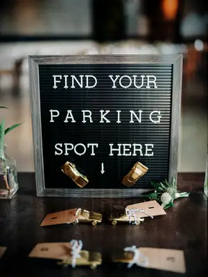 DIY wedding decoration of golden toy cars for escort card display.