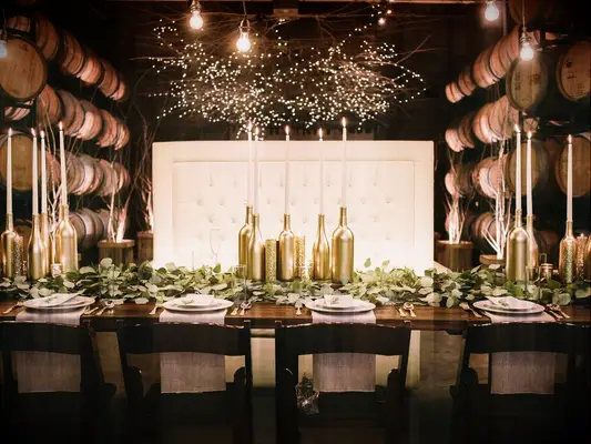 Gold spray-painted wine bottles for DIY wedding decor project.