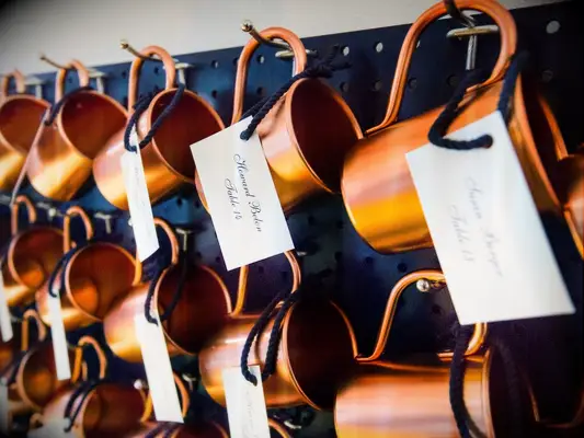 Wedding DIY decor of copper mug escort card display.