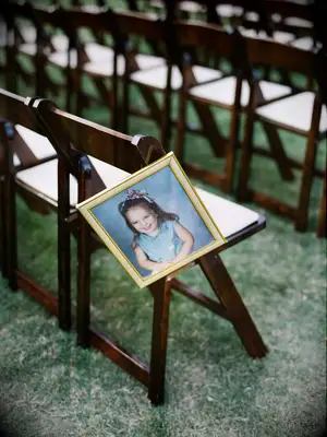 Photo of bride in frame hanging from ceremony chair. 
