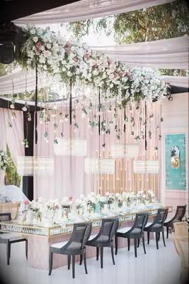 glam hanging flowers wedding with pink and white roses, and crystal chandeliers on black ribbons hanging from ceiling