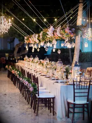 romantic hanging wedding centerpiece with pink roses, greenery and votive candles in glass orbs