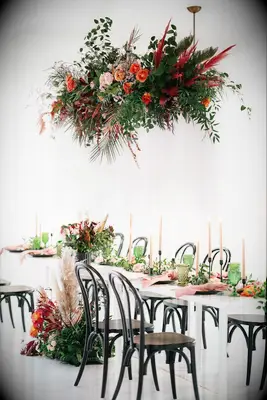 modern hanging flowers wedding centerpiece with red, orange and pink flowers and greenery