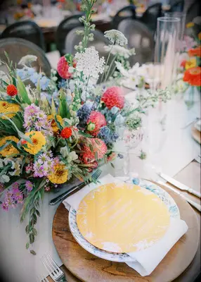 Wildflowers and wood chargers at wedding reception