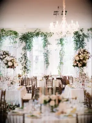 Indoor wedding reception with crystal chandeliers and greenery garlands