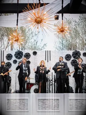 Wedding band dancing on modern black-and-white stage