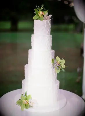 five tier white wedding cake with textured buttercream and green orchids