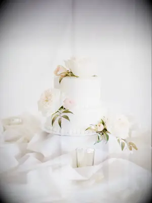 simple classic two tier wedding cake decorated with white buttercream ivory garden roses and blush rosebuds