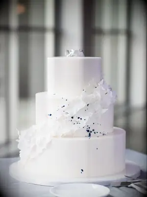 Simple three-tier white wedding cake with color splatter