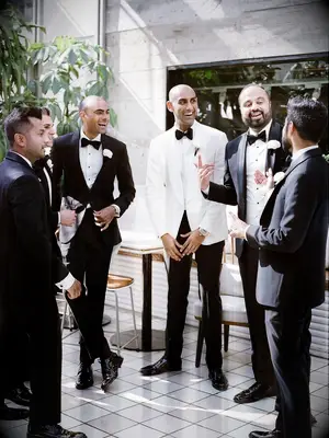 Candid photo of groom talking with groomsmen during wedding