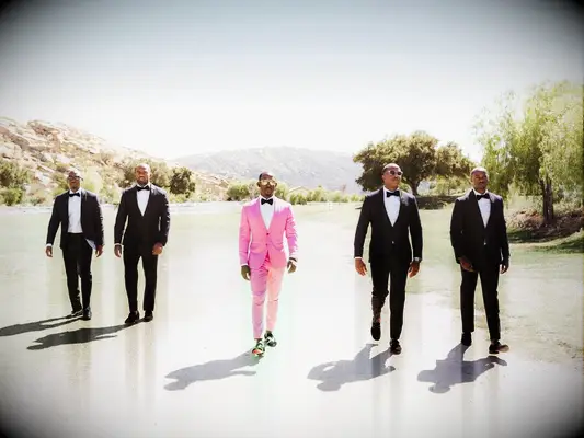 Groom and groomsmen walking outside scenic mountain wedding venue