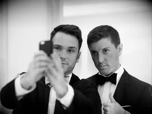 Groomsmen taking selfie on wedding day